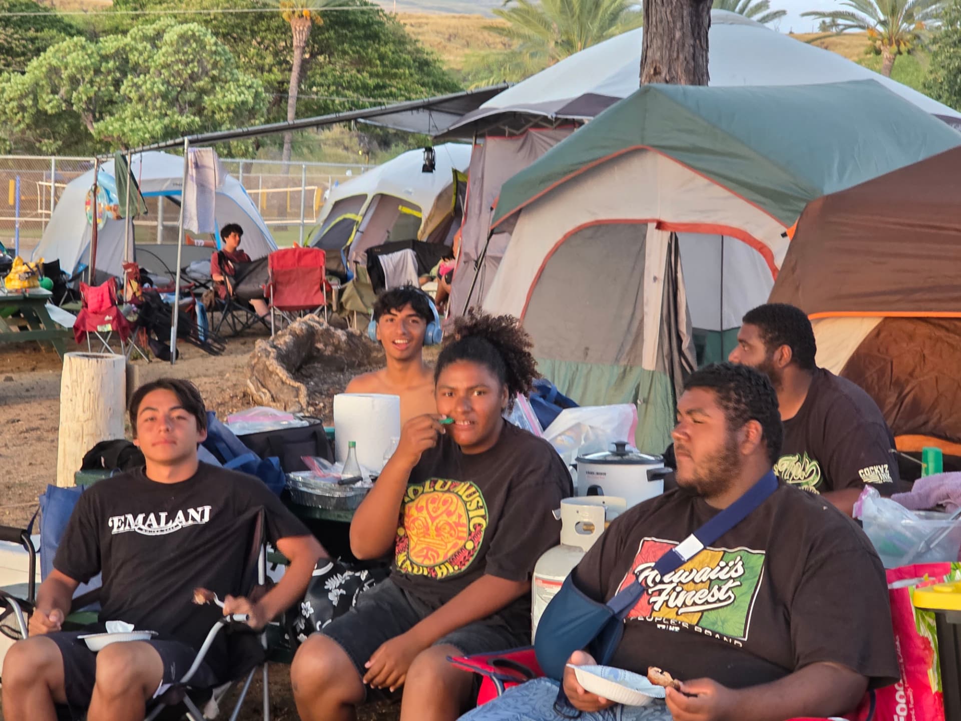 Campers relaxing among tents at the Hawaiʻi Island youth camp